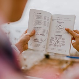 Global Business Competence Center for SMEs Quelqu'un en train de lire un livre rempli de graphiques