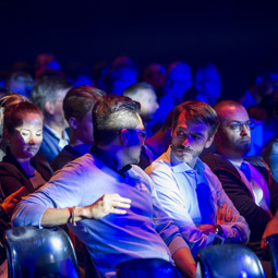 TOUS LES ÉVÉNEMENTS People sitting in an auditorium during an event