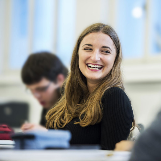 Studentin, lachend, während einer Vorlesung