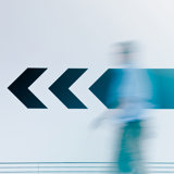 Flèche sur un mur de corridor avec une personne floutée 