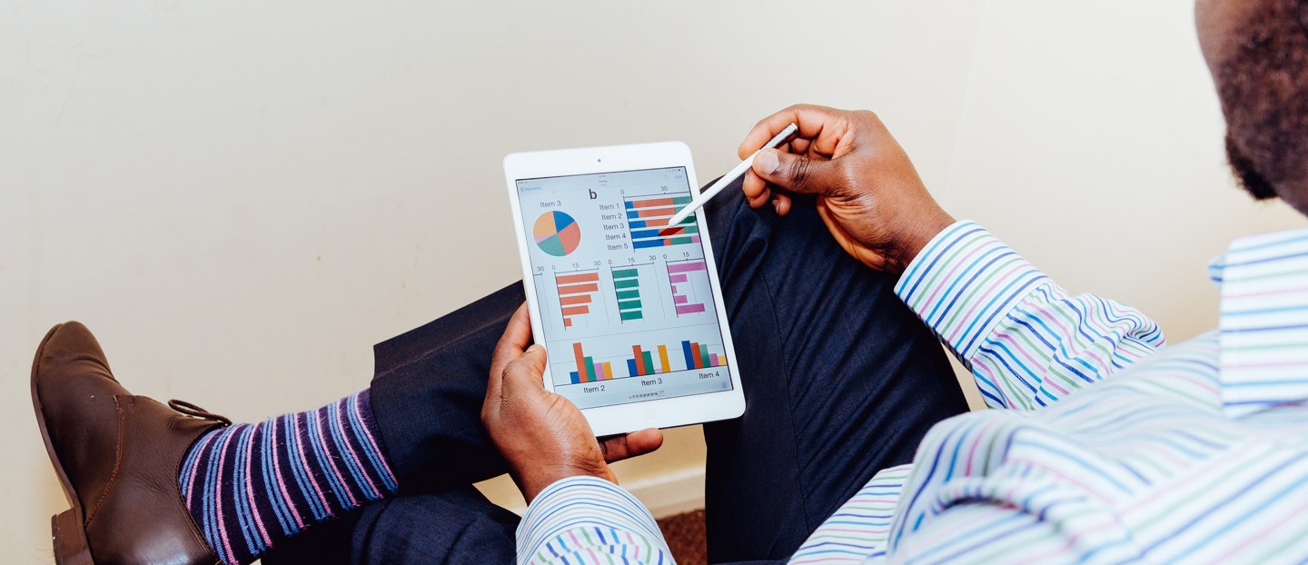Un homme avec une tablette montrant des graphiques